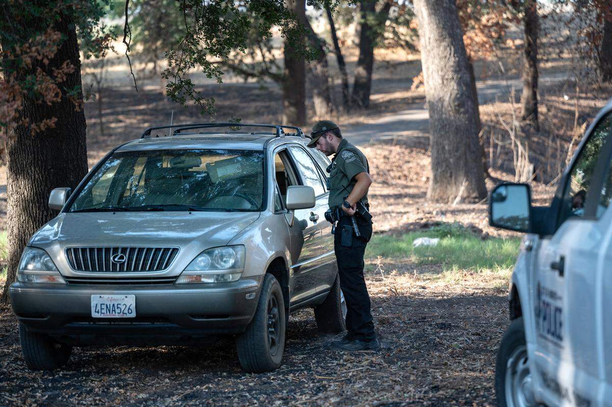Modesto park ranger Justin Rocha investigates an abandoned car in Tuolumne Regional Park in Modesto, Calif., on Friday, September 9, 2022.
