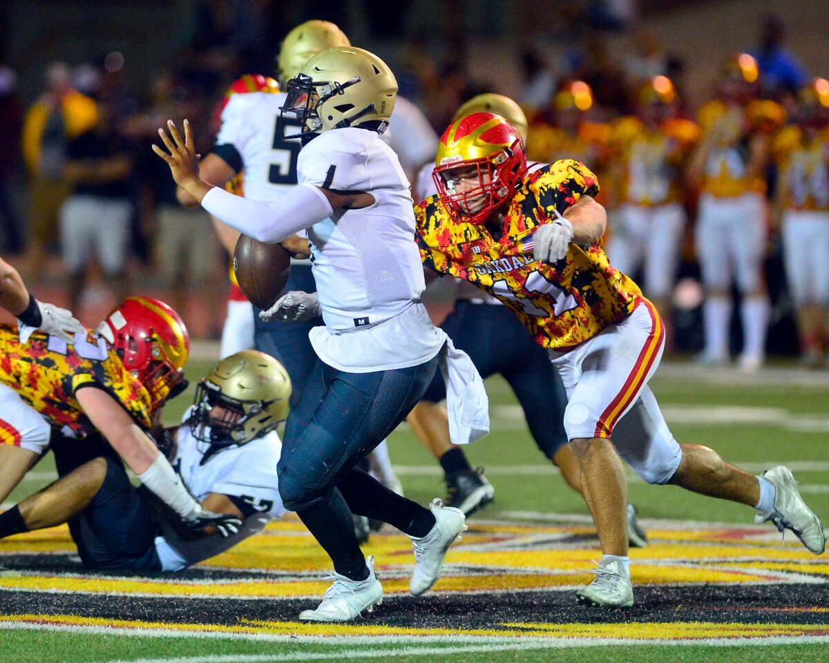 Oakdale’s Cam Loureiro (11) sacks Archbishop Mitty’s quarterback Wills Towers (1) during a football game between Oakdale High School and Archbishop Mitty High School at Oakdale High School in Oakdale California on September 10, 2021.
