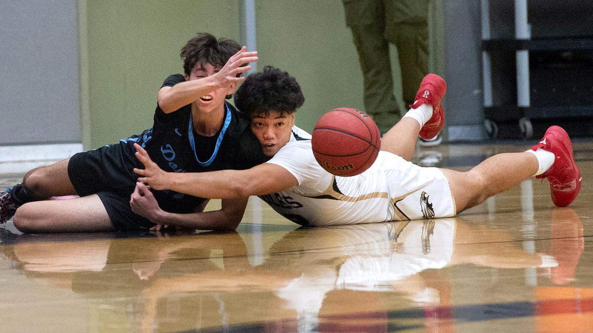 Downey’s Collin Eden gets a pass away from Enochs Troy Navarro after a scramble for ball during the Central California Athletic League game at Enochs High School in Modesto, Calif., Friday, Jan. 27, 2023. Downey won the game 47-40.