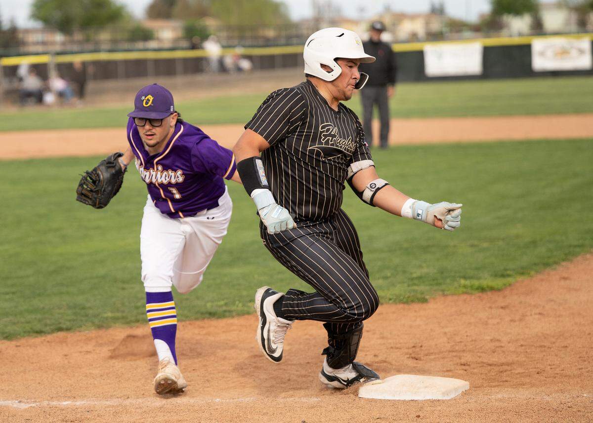 Hughson’s Carlos Guizar legs out a single past the tag of Orestimba’s Colby Cabral during a Trans-Valley League game in Hughson, Calif., Friday, March 28, 2025.
