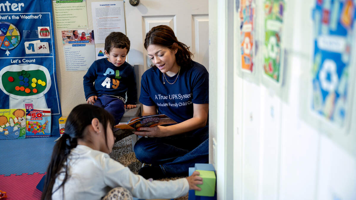 Childcare provider Adriana Segura reads a book about the solar system to Liam Galvez, 2, at her daycare in Patterson, Friday, April 24, 2026.