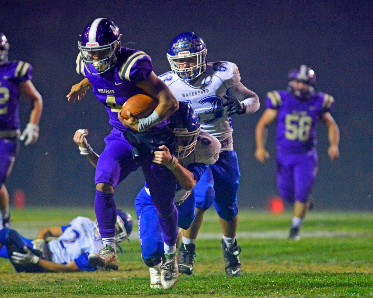 Livingston quarterback Rocklin Baptista (4) shakes free from a Waterford defender during a 2021 CIF Sac-Joaquin Division VI playoff game between Livingston High School and Waterford High School at Livingston High School in Livingston, California on November 12, 2021