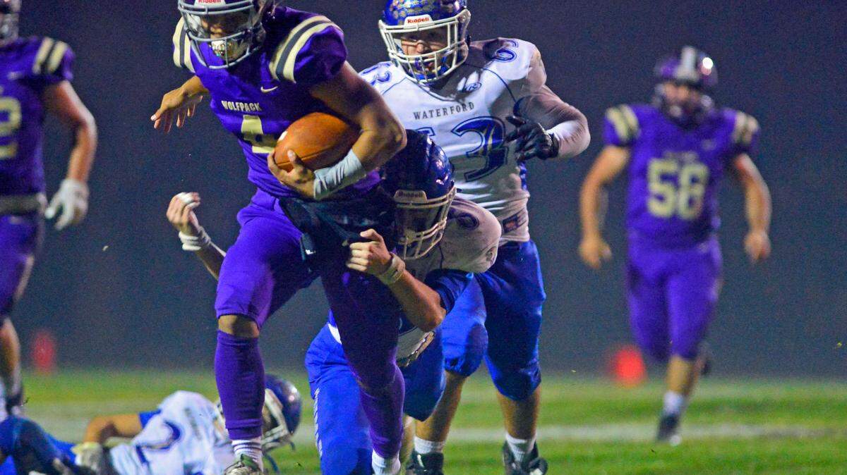 Livingston quarterback Rocklin Baptista (4) shakes free from a Waterford defender during a 2021 CIF Sac-Joaquin Division VI playoff game between Livingston High School and Waterford High School at Livingston High School in Livingston, California on November 12, 2021