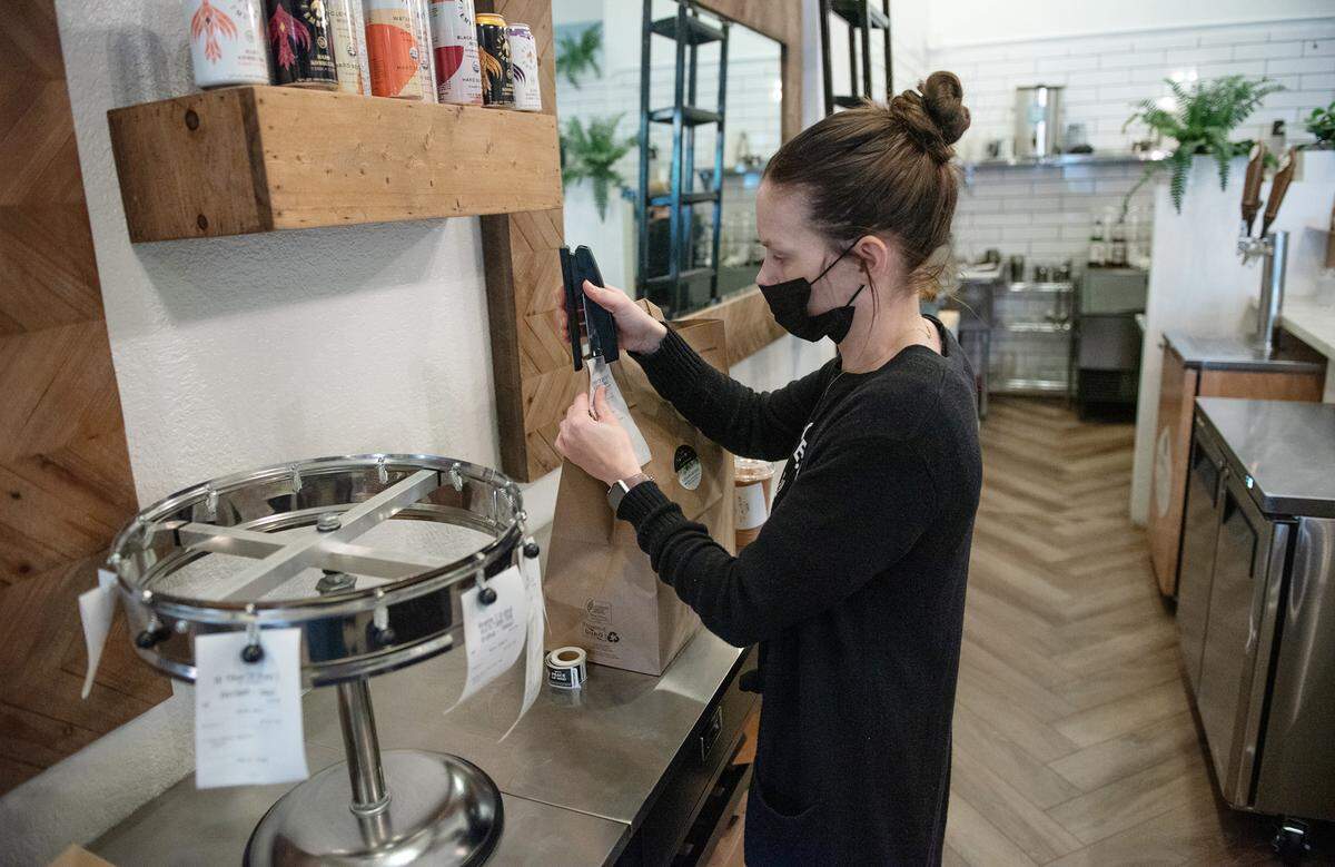 Farmacy restaurant manager Rachel Morrisette prepares a take-out order in Modesto, Calif., on Thursday, Jan. 6, 2022. The restaurant closed to indoor dining due to the spike in COVID-19 cases.