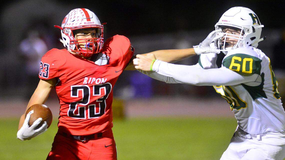 Ripon receiver Danny Hernandez (23) stiff arms Hilmar defender Brennan Mason (60) during a game between Ripon and Hilmar at Ripon High School in Ripon CA on September 14, 2018.

