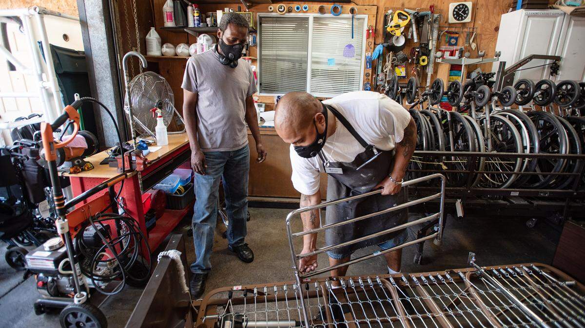 Durable medical Equipment specialist Zach Smith, right, and assistant Lawrence Crockett, left, inspect a medical bed at The Society for Disabilities in Modesto, Calif., on Thursday, July 23, 2020.