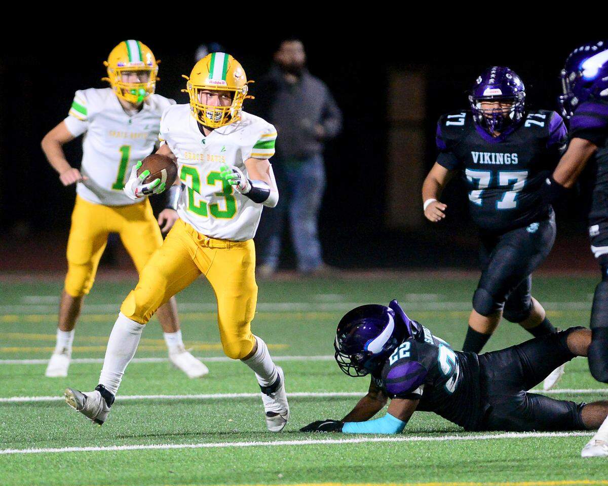 Davis running back Ezekiel Suarez (23) sprints away from multiple defenders during a game between Johansen and Davis at Johansen High School in Modesto California on November 1, 2024.