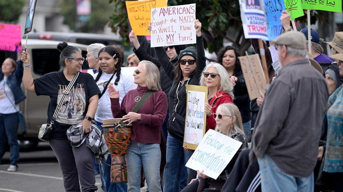 Protesters call out to motorists on J Street to protest Trump administration policies in Modesto, Feb. 24, 2025.