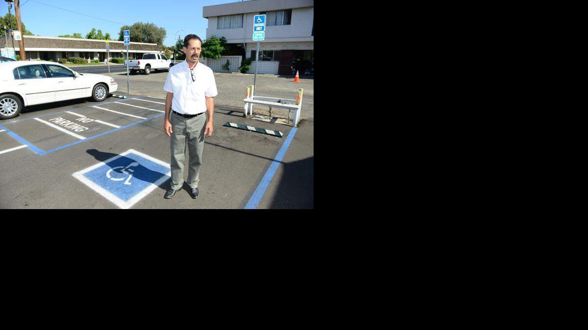 Bar B-Q Pit owner Roy Mercado stands in the parking lot of his restaurant on Wednesday. Inappropriate parking was one of the claims in an Americans with Disabilities Act lawsuit filed against Mercado.
