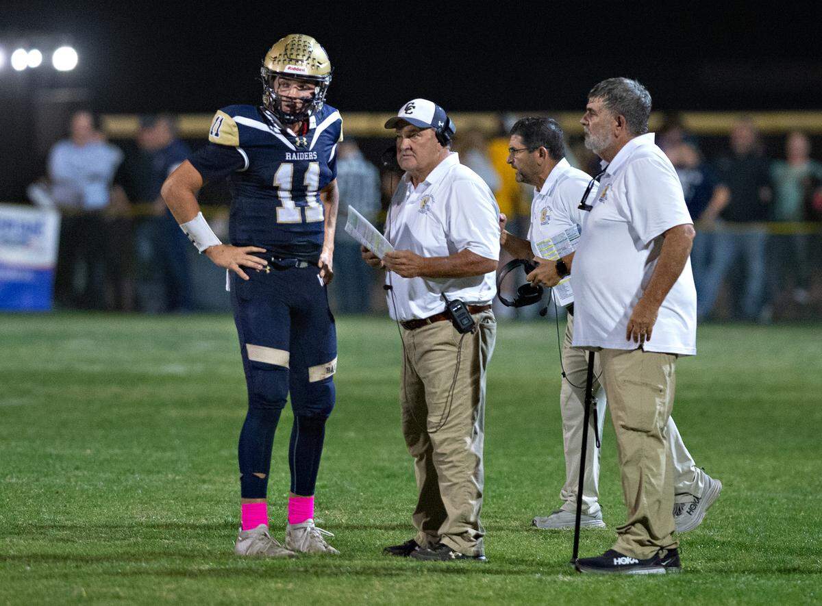 Central Catholic head coach Roger Canepa, middle, talks with quarterback Tyler Wentworth during the Valley Oak League game with Oakdale in Modesto, Calif., Friday, Oct. 14, 2022.