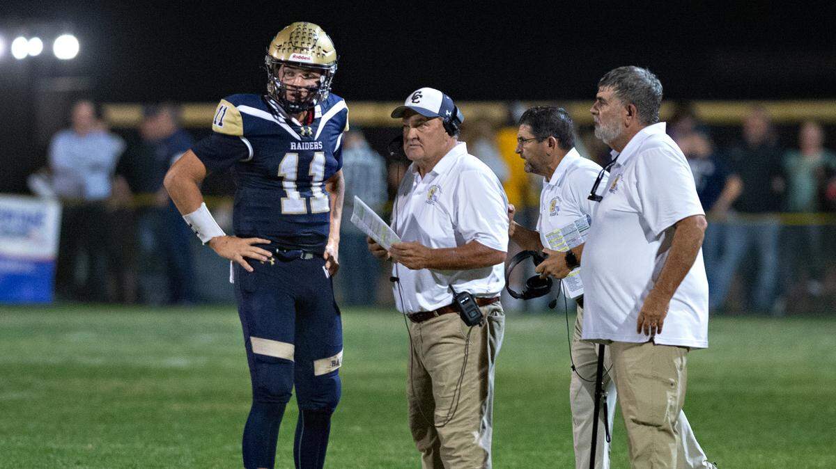 Central Catholic head coach Roger Canepa, middle, talks with quarterback Tyler Wentworth during the Valley Oak League game with Oakdale in Modesto, Calif., Friday, Oct. 14, 2022.