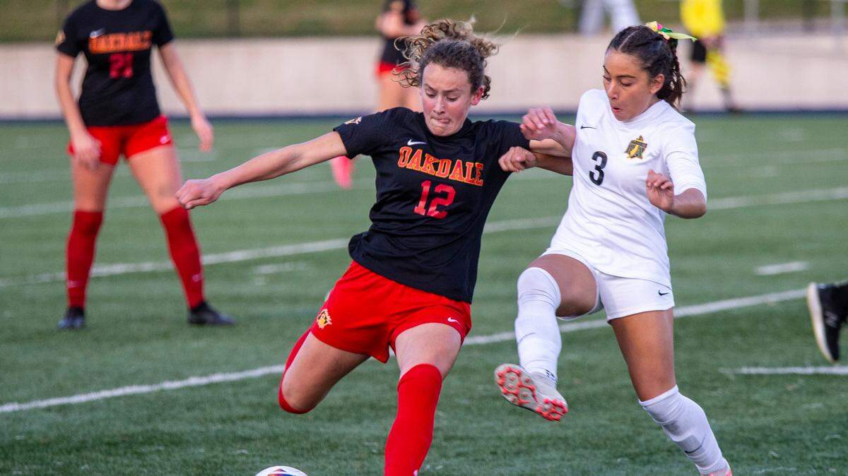 Oakdale High’s Dakota Burford, 12, fights for control of the ball against Hannah Hopkins, 3, of Rio Americano High during the Sac-Joaquin Section Division III Section Championship match Thursday Feb. 22, 2024 at Cosumnes River College.