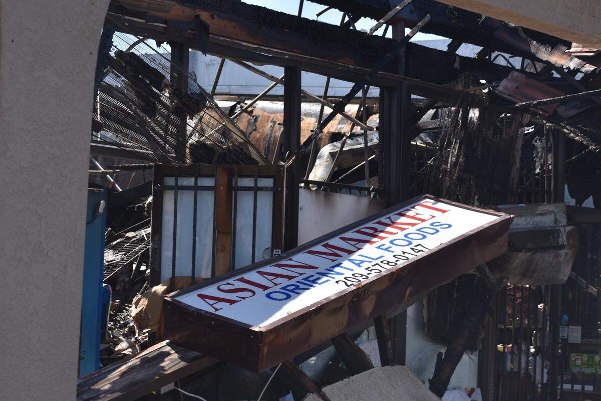The sign for the Asian Market sits on a pile of wreckage after a fire destroyed the business Saturday June 8, 2019, at the shopping center in the 1100 block of Carver Road in Modesto, California.