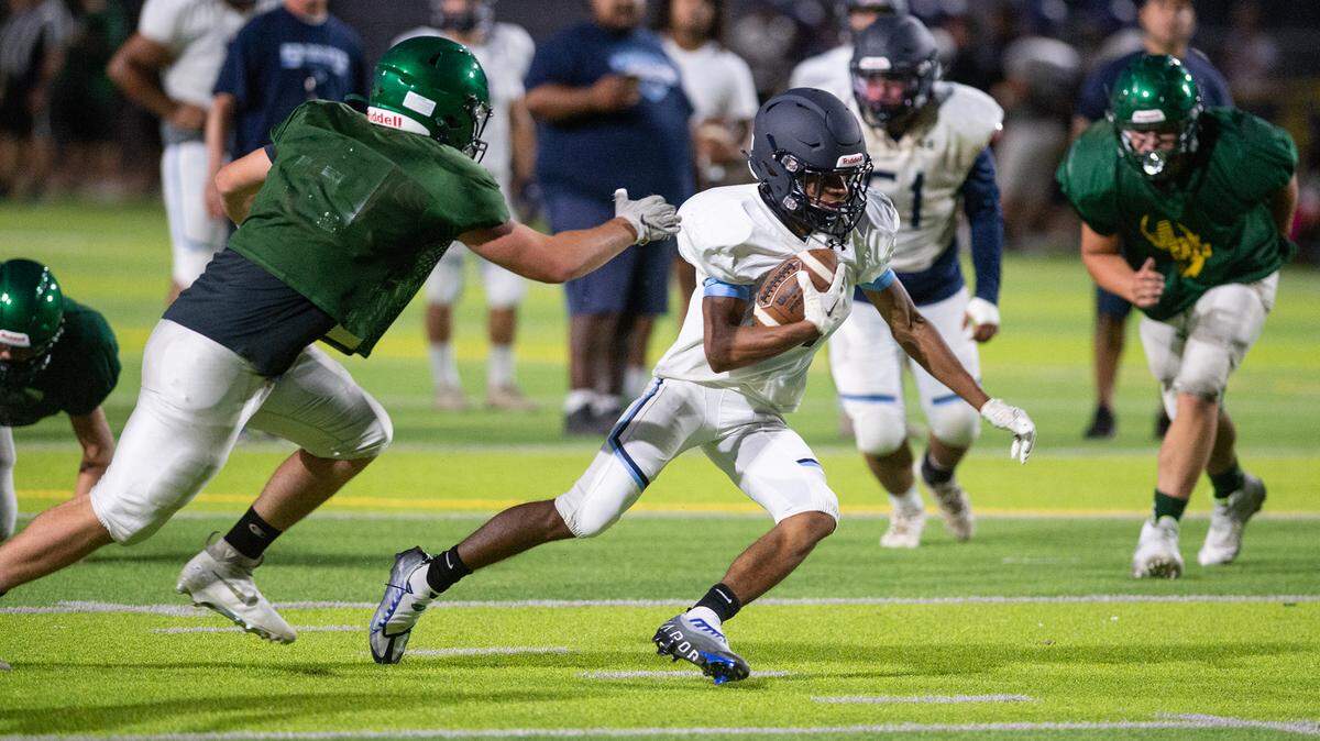 A Downey runningback evades a Sonora defender during a pre-season scrimmage at Downey High School in Modesto, Calif., on Friday, August 12, 2022.