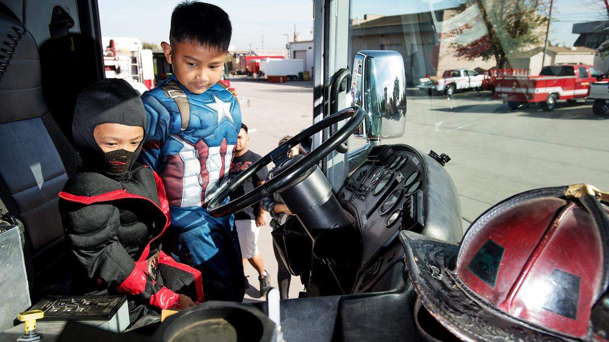Cousins Zane Cham, 5, left, and Landen Niem, 6, sit in the drivers seat of a Burbank Fire Department fire truck at the First Responders Trunk or Treat at the Regional Fire Training Center in Modesto, Ca., on Saturday, Oct. 27, 2018.