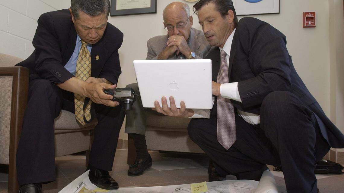 Dr. Henry Lee, left and pathologist Cyril Wecht, center, discuss a satanic ritual theory in the disappearance of Modesto’s Laci Peterson with attorney Matt Dalton in the lobby of a crime lab in Ripon in 2003.