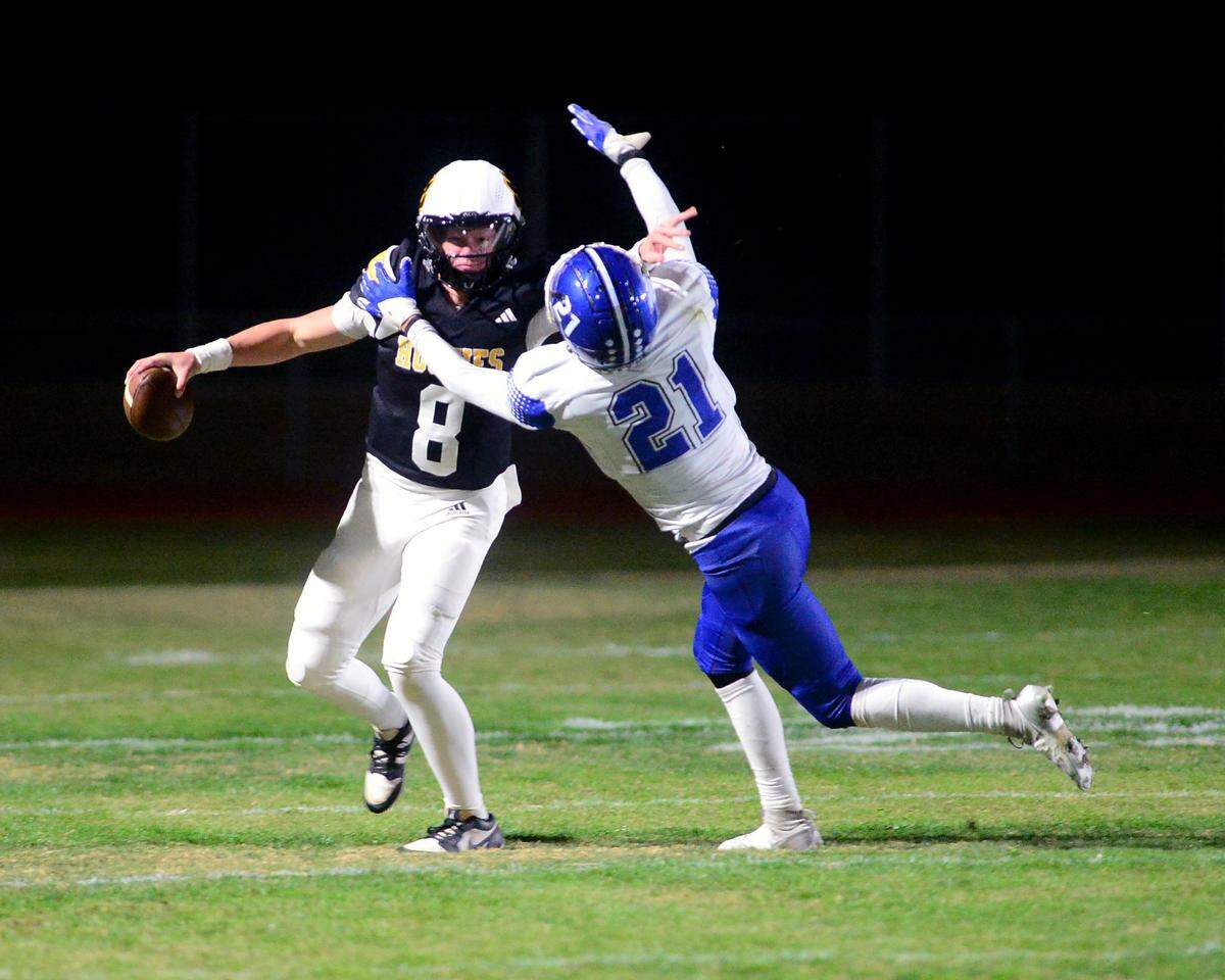 Hughson quarterback Robert McDaniel (8) fights off El Dorado defender Leon Valadez during a 2024 CIF Sac-Joaquin Section Division V Playoff game between Hughson High School and El Dorado High School at Hughson High School in Hughson California on November 15, 2024. Hughson won the game 28-6.