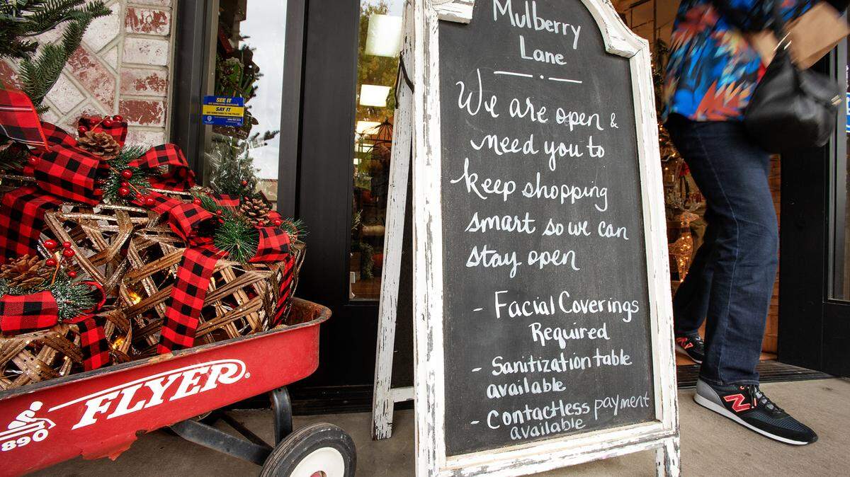 A customer leaves Mulberry Lane in McHenry Village in Modesto, Calif., on Tuesday, Nov. 17, 2020. Under new restrictions, retailers are giving customers guidelines to follow in their stores.
