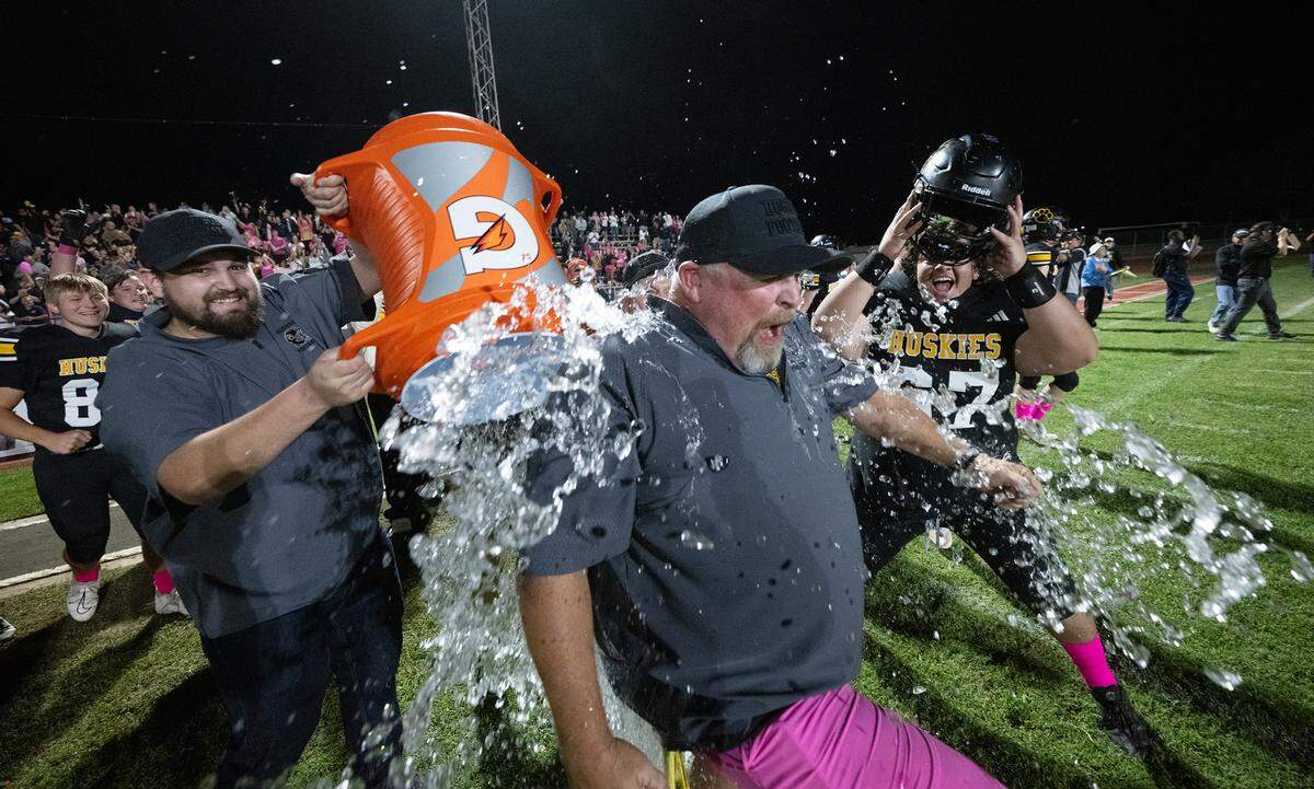 Hughson coach Shaun King is splashed with water after the Huskies 52-51 win over Sonora in the Trans Valley League game in Hughson, Friday, Oct. 11, 2024.