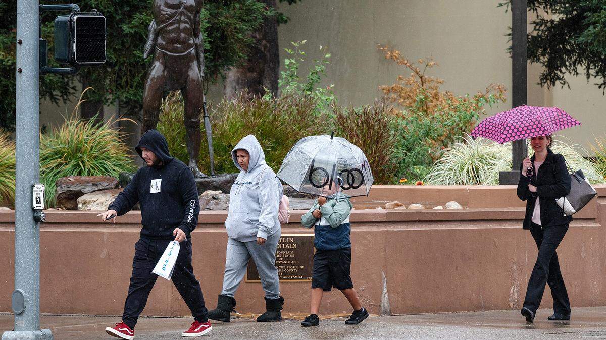 People break out the umbrellas during an afternoon rain storm in Modesto, Calif., Tuesday, Nov. 1, 2022.