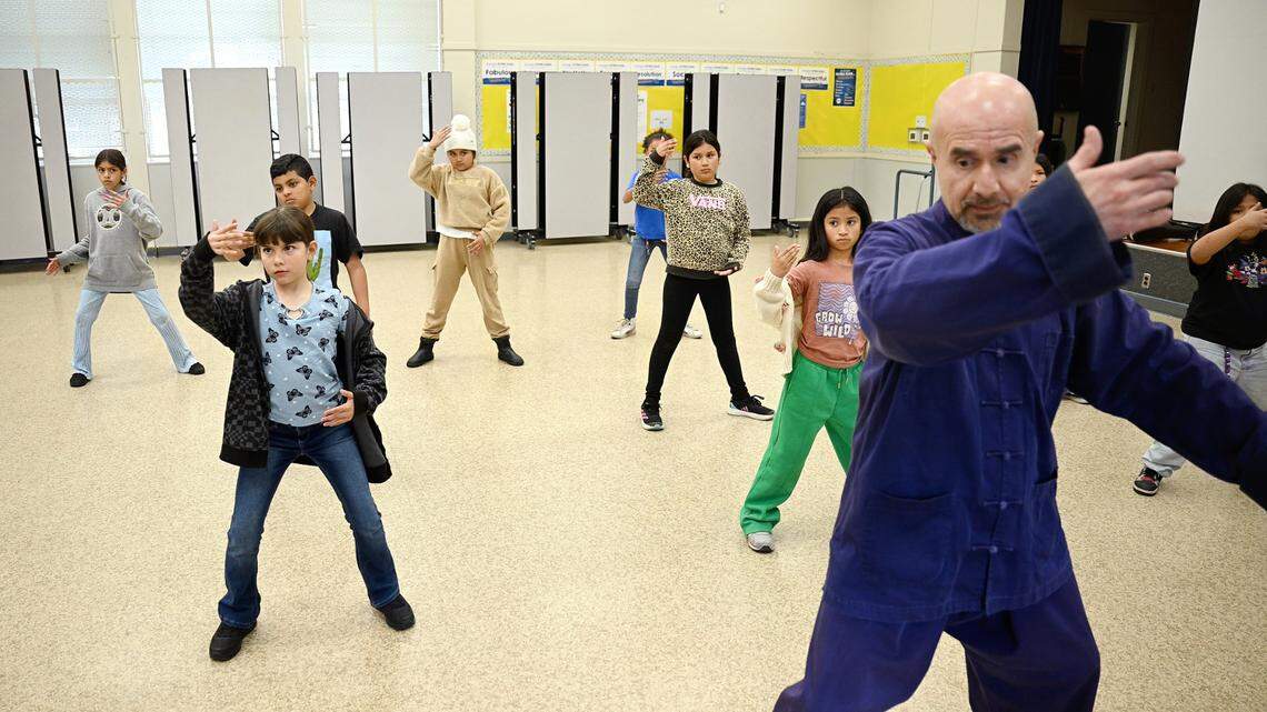 Instructor Naser Ataee, right, leads students in tai chi movements at Orville Wright Elementary School in Modesto on Thursday, March, 13, 2025.