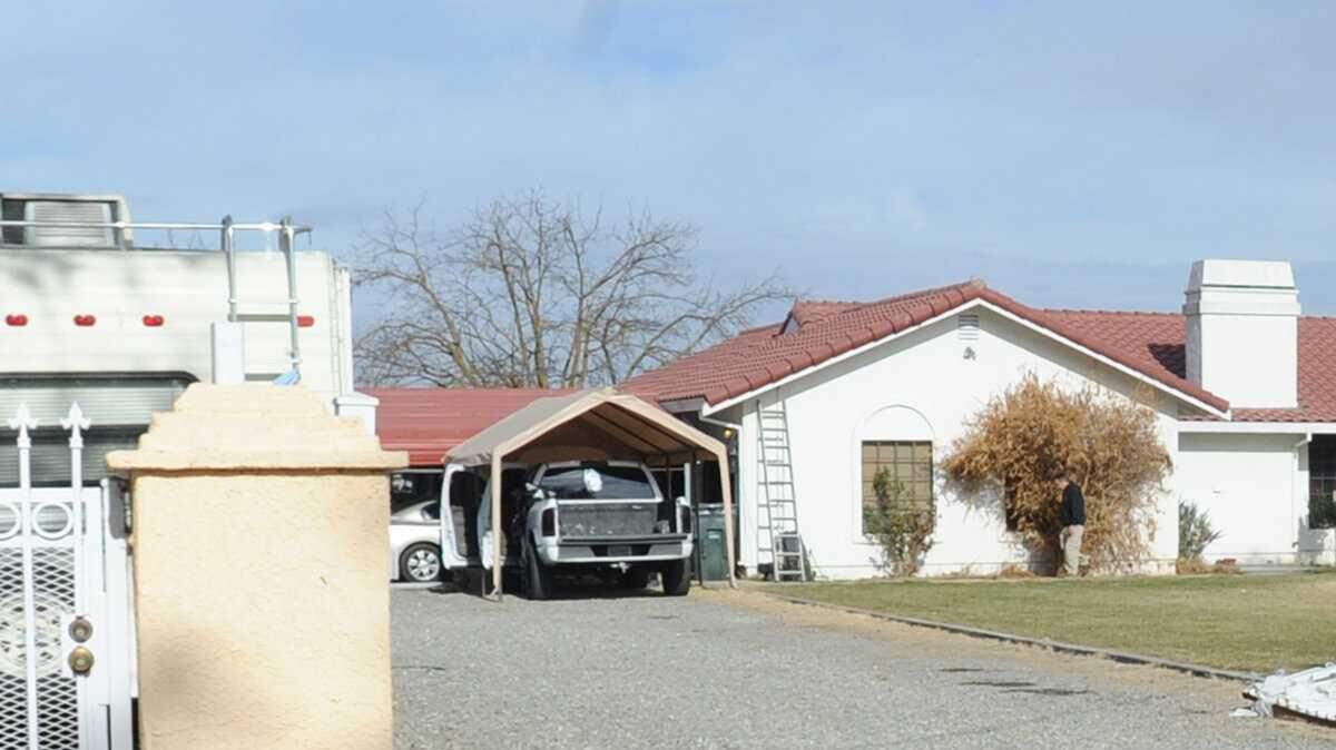 Law enforcement agents conduct a search on the 2000 block of Orange Avenue after breaking down the front gate Tuesday morning (01-29-14).