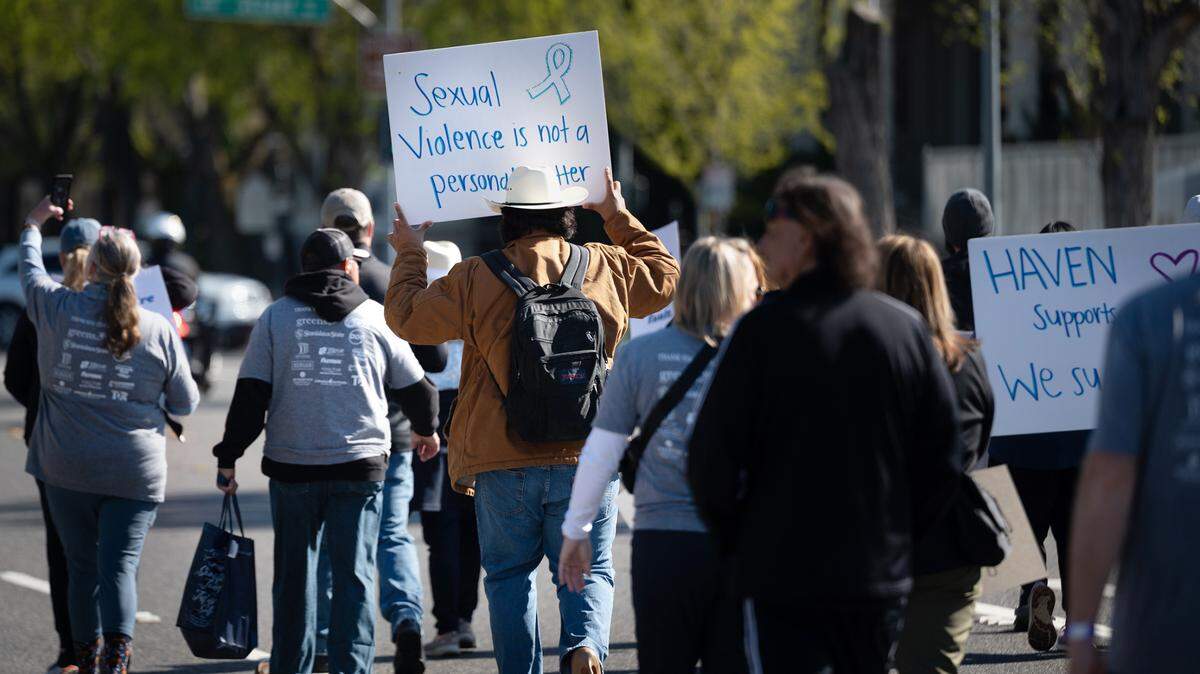 Participants walk down I Street during the In Their Shoes fundraising walk for HAVEN in Modesto, Calif., Saturday, April 1, 2023. HAVEN stands for Healthy Alternatives to Violent Environments and provides support services for victims of domestic violence, sexual assault and human trafficking in Stanislaus County.
