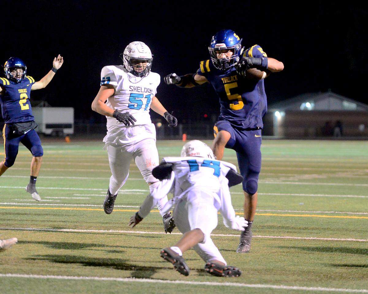 Turlock running back Jeremiah Bertalotto (5) leaps over a Sheldon defender to score a touchdown during a CIF Sac-Joaquin Section Football Division I playoff game between Turlock High School and Sheldon High School at Turlock High School in Turlock, California on Nov. 3, 2023.