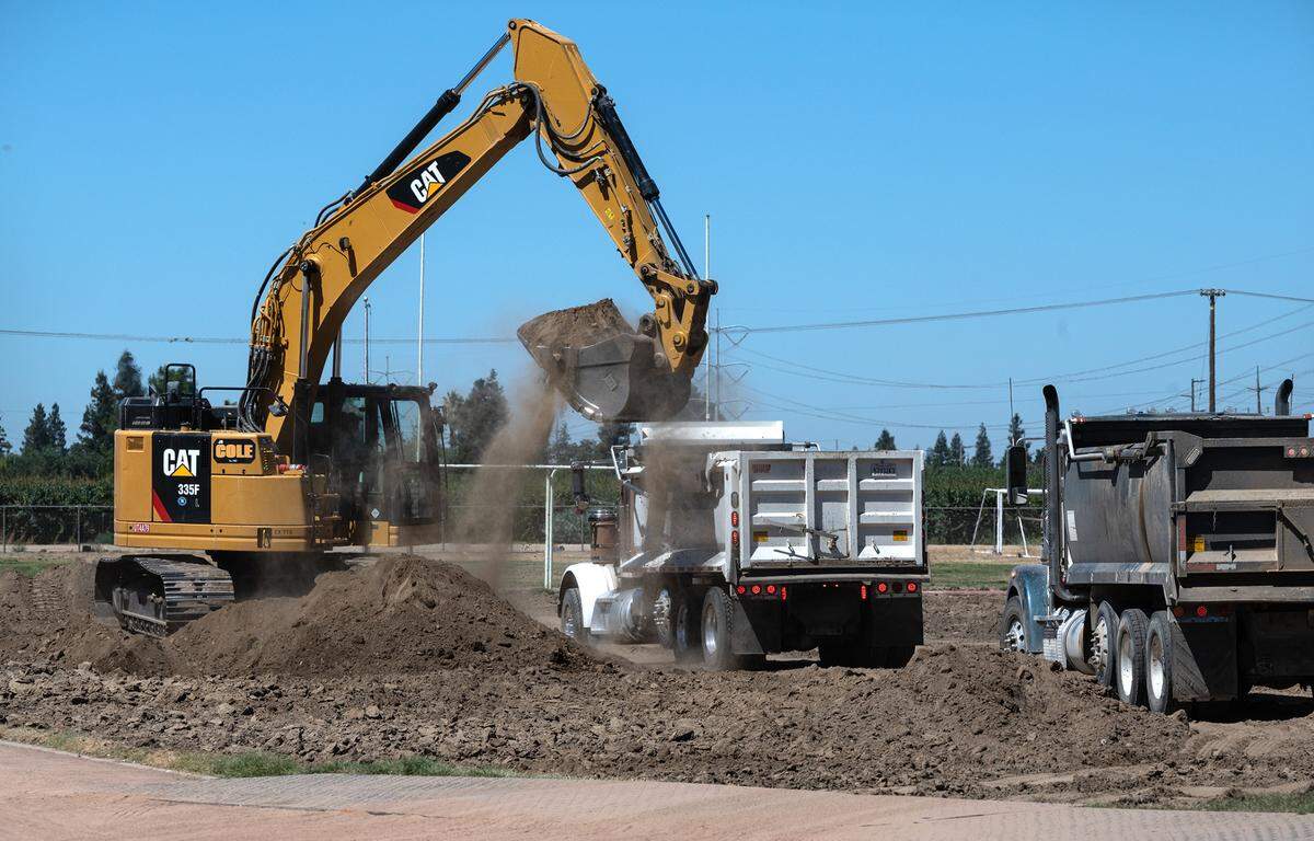 A crew prepares Johansen High School’s stadium for new artificial turf in Modesto, Calif., on Thursday, July 21, 2022.