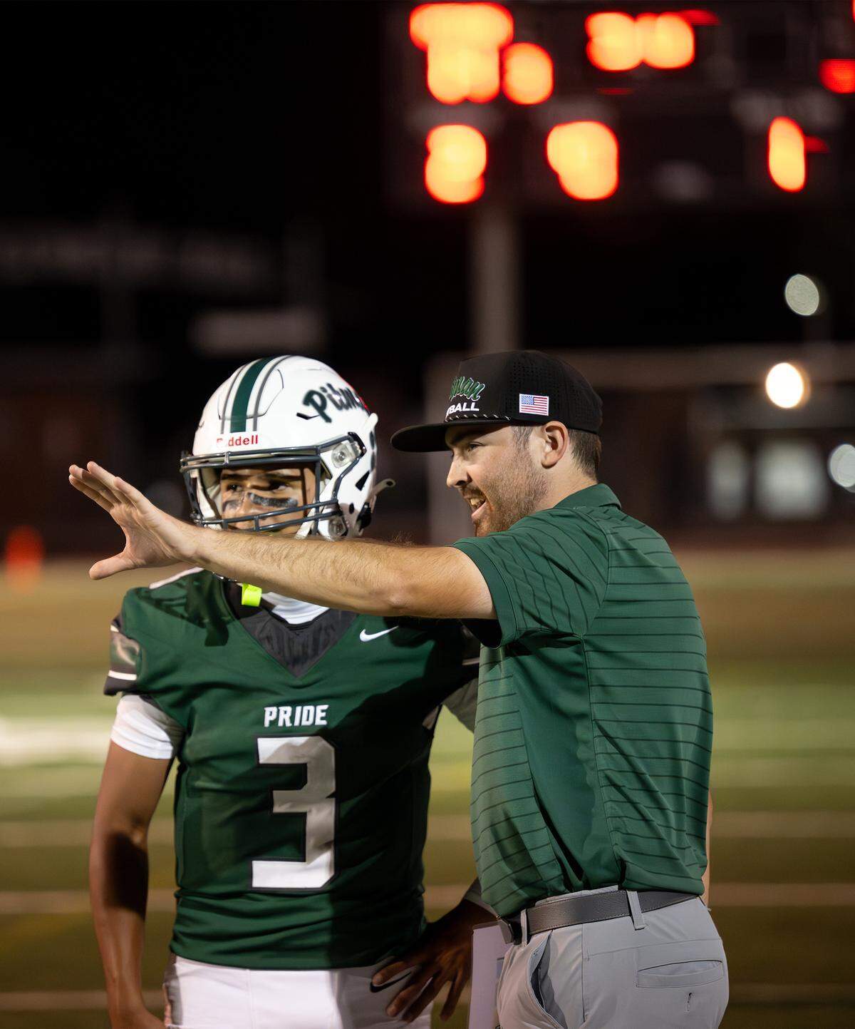 Pitman head coach Braden Plaa talks with quarterback RJ Wilharm during the game with Hughson at Turlock High School in Turlock on  Friday, Sept. 5, 2025.