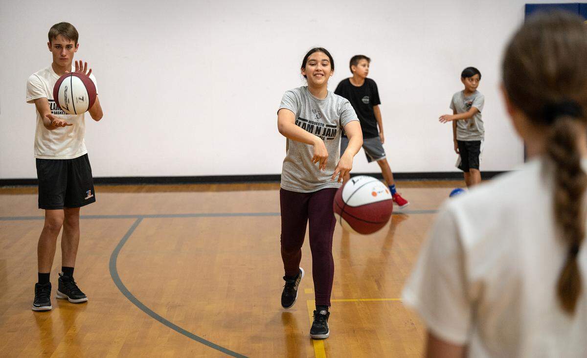Camp participant Marissa Martinez, right, works with others on a passing drill during the Modesto Slam-N-Jam basketball camp at Big Valley Christian in Modesto, Calif., on Tuesday, July 5, 2022.
