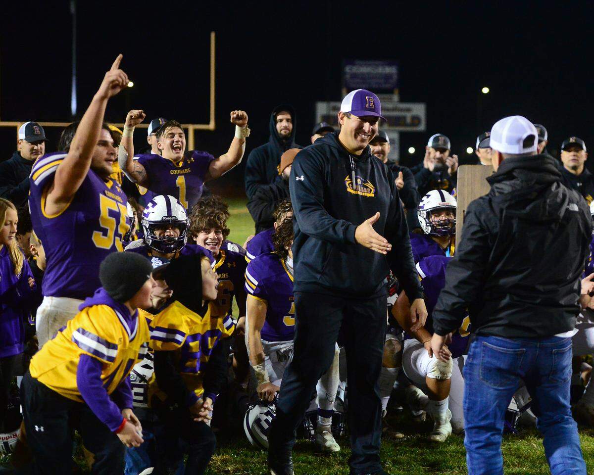 Escalon Head Coach is presented the 2022 Division 4-AA NorCal plaque while his team celebrates after the 2022 CIF NorCal Division 4-AA Bowl Game between Escalon High School and Pleasant Valley High School at Escalon High School in Escalon CA on Dec. 2, 2022. Escalon won the game 42-20.