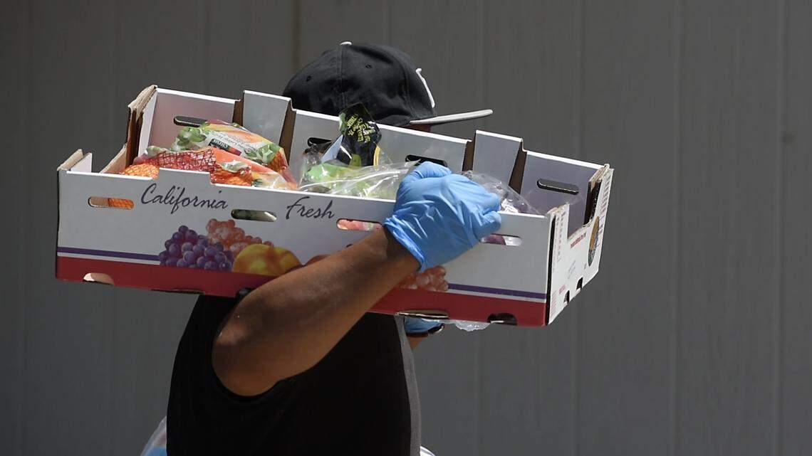 Arturo Hernandez helps distribute food in Westley in August. Golden Valley Health Center, Second Harvest Food Bank, Central Valley Opportunity Center and Rep, Josh Harder joined together to distribute food, as well as COVID supplies to a Stanislaus County Housing Authority farm family neighborhood in Westley , Calif., on Tuesday Aug. 11, 2020.