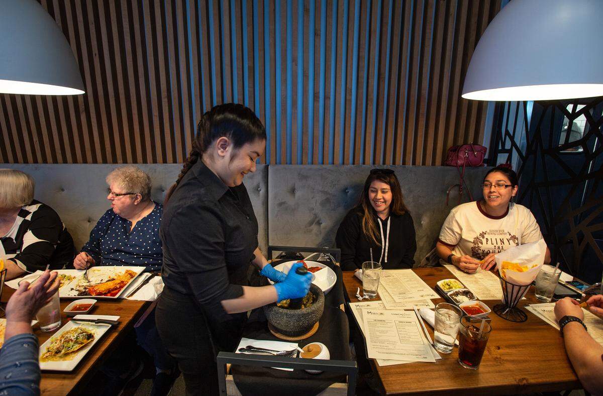 Savannah Havens prepares salsa table side at Memo’s Cocina & Tequila Bar in Modesto, Calif., on Thursday, Feb. 24, 2022.