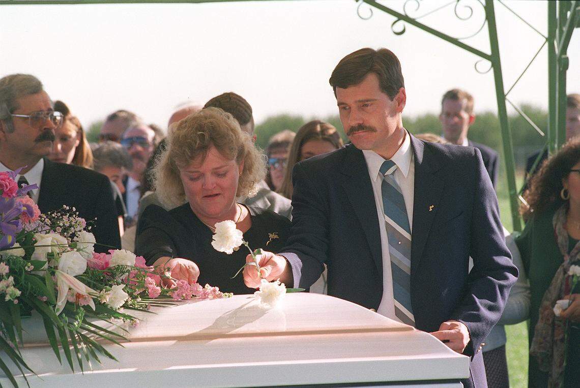 Kathy Mouser watches as stepfather Doug Mouser places a flower on the casket of Genna Gamble in October 1995.