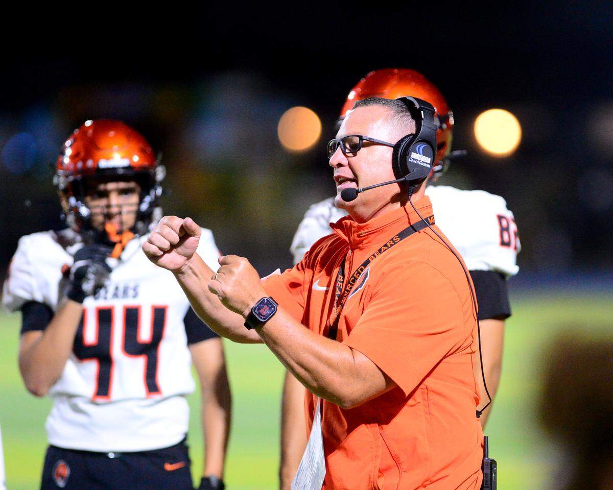 Merced Head Coach Rob Scheidt talks to his players during a game between Downey High School and Merced High School at Downey High School in Modesto California on September 1, 2023.