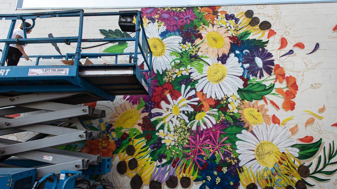 Artist Patty Pratt works on a mural on 13th Street as part of the DoMo Walls mural festival in Modesto, Calif., on Tuesday, Oct. 5, 2021.