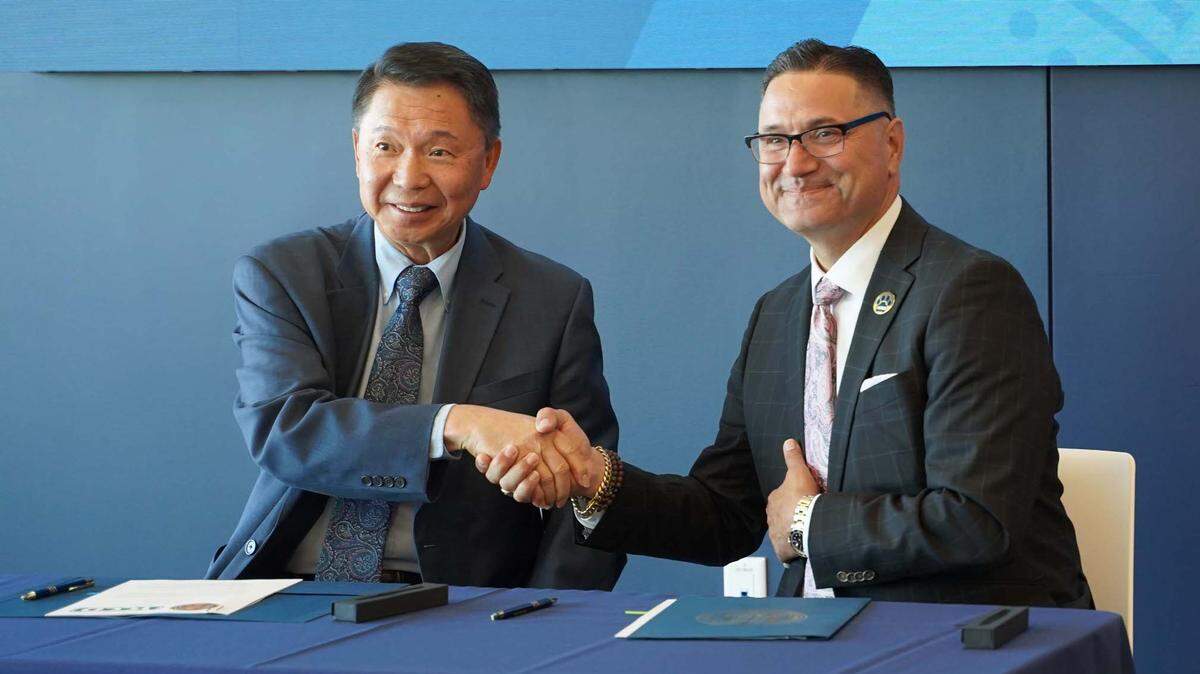 Henry C.V. Yong, rector del Yosemite Community College District (izquierda), y Juan Sánchez Muñoz, rector de la UC Merced, se dan la mano tras la firma del memorando de entendimiento del Merced Promise Pathway.