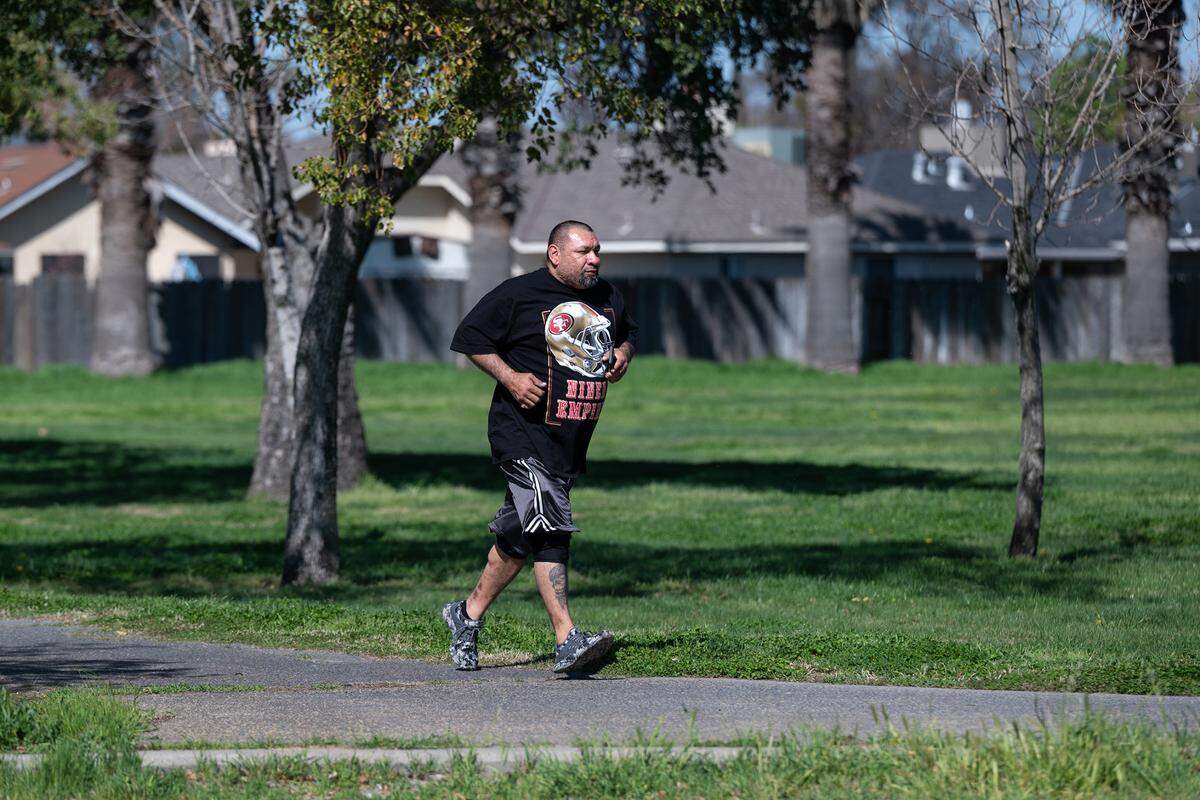 Mike Espinoza runs on the walking path at Mancini Park in Modesto, Calif., Thursday, March 16, 2023.