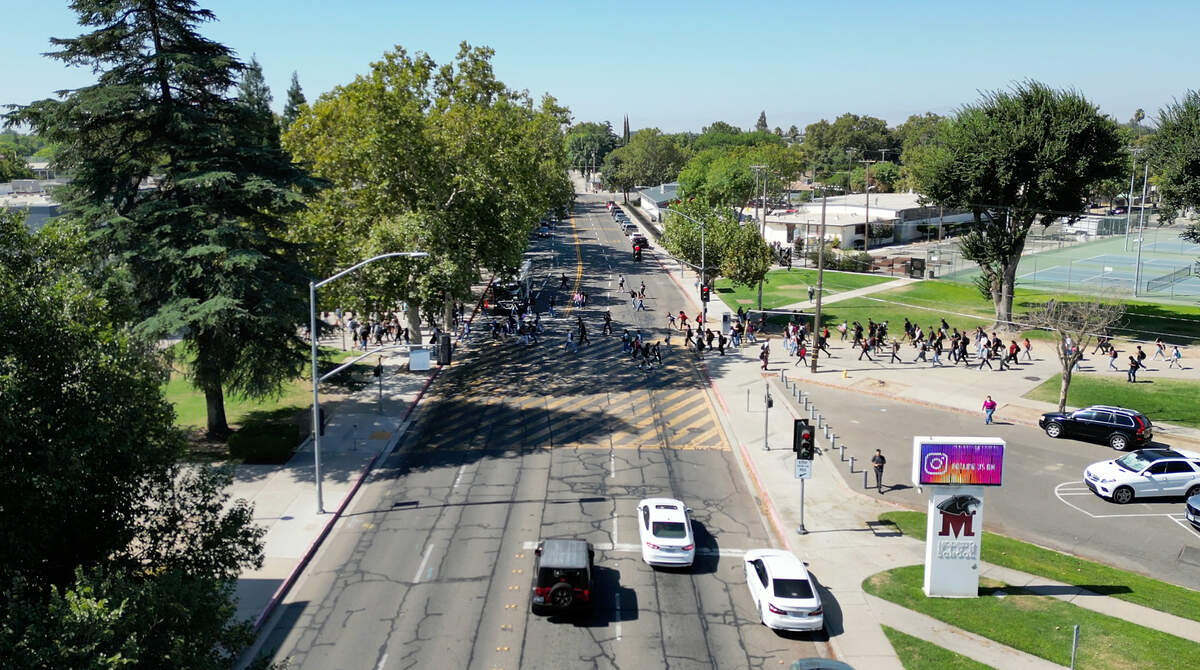 Modesto High School students cross H Street in Modesto, Calif., Wednesday, September 6, 2023. By the fall of 2024 the four lanes of H Street in front of Modesto High will be reduced to two lanes as part of a $11.5 million city project to improve safety for people on foot and bicycle.