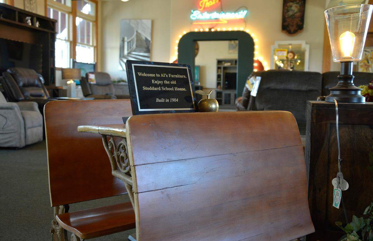 An old school-house desk with a plaque commemorating the building’s beginning as Stoddard School inside Al’s Furniture in Modesto, Calif.