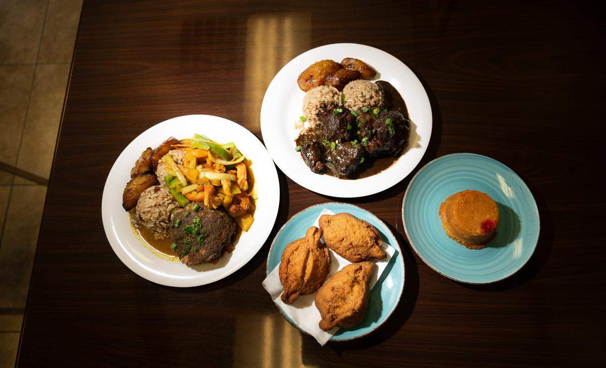 Caribbean food items jerk chicken and curry shrimp, left, oxtail, top, fried cornbread and pineapple cake at Cariblue restaurant in Modesto 