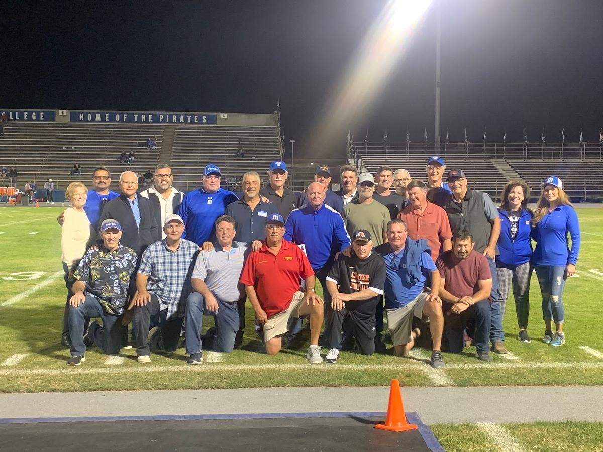 Honorees from the Modesto Junior College 1980 National Championship team pose for a photo at halftime on Oct. 16, 2021