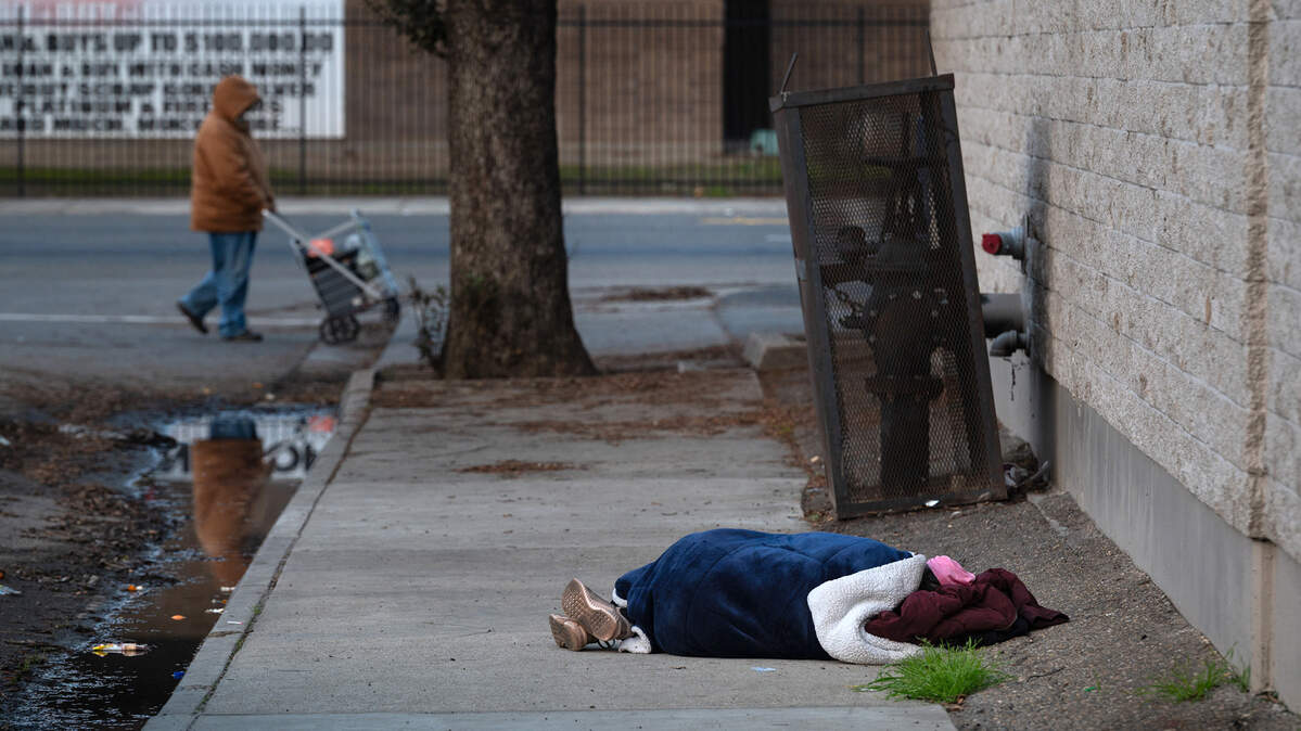 A homeless person sleeps behind the Modesto Gospel Mission.
