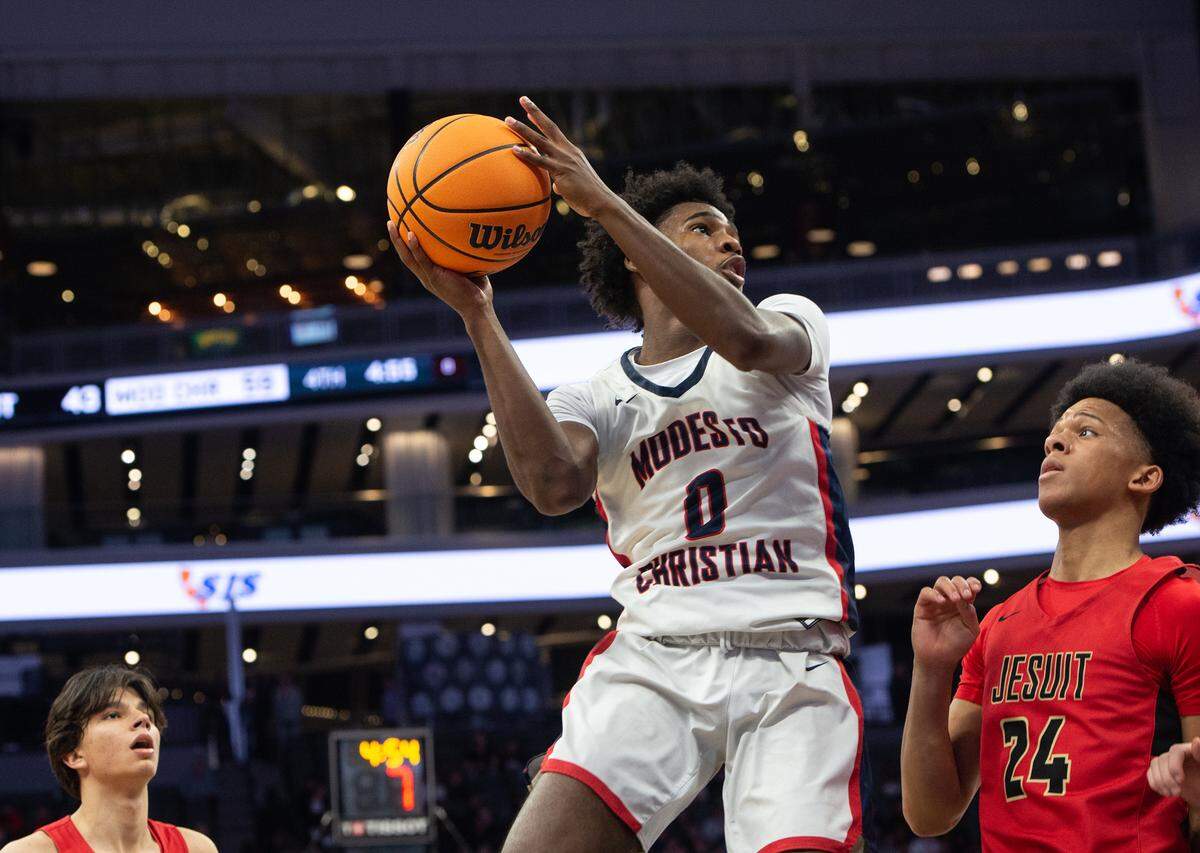 Modesto Christian’s Jalen Brown scores on a layup over Jesuit’s Ahjani Lewis during the Sac-Joaquin Section Division I championship game at Golden 1 Center in Sacramento, Calif., Saturday, Feb. 25, 2023.