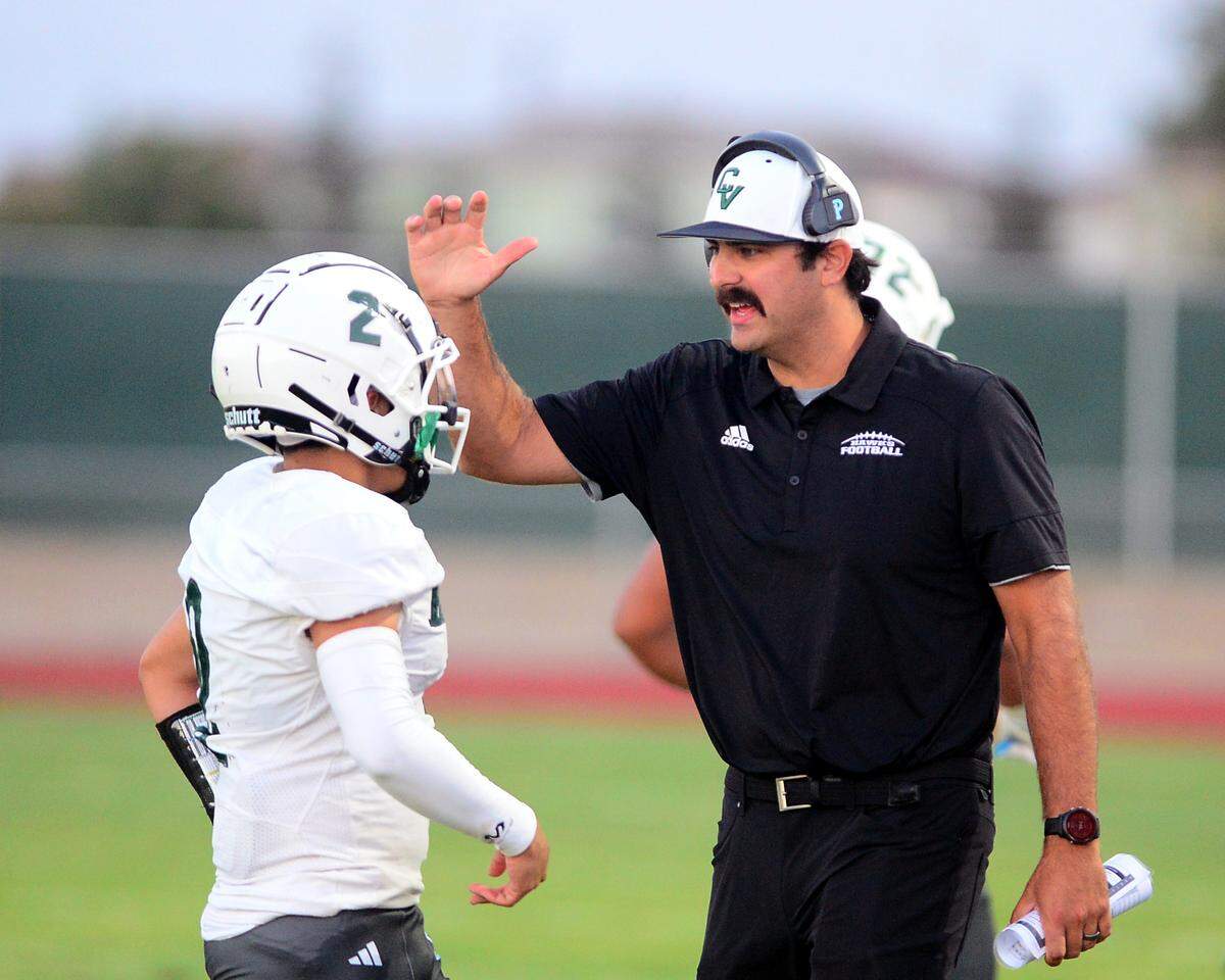 Central Valley Head Coach Derrick Goblirsch talks with Mario Gonzalez during a game between Hughson High School and Central Valley High School at Hughson High School in Hughson California on August 25, 2023.