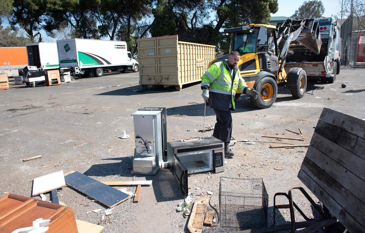 Bertolotti worker Hector Camacho separates trash during Modesto’s “drive up, drop off” bulky item refuse collection event at John Thurman Field in Modesto, Calif., Saturday, March 25, 2023.