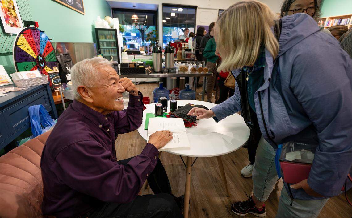 Author David Mas Masumoto signs a copy of his book “Secret Harvests” for Carolyn Pellegrini during the first meeting of The Modesto Bee book club at Bookish bookstore in Modesto on Tuesday, April 21, 2026.