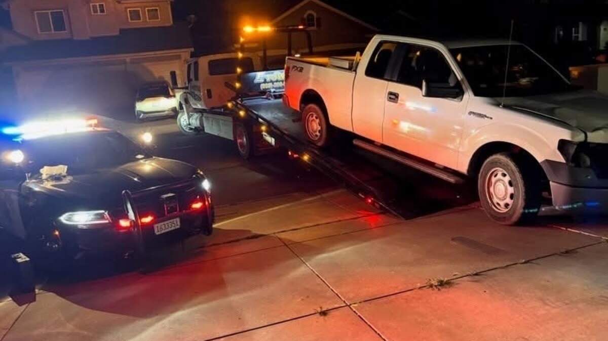 A white Ford F-150 believed to be involved in a fatal hit-and-run crash that killed a Modesto woman is towed away by authorities after being located by investigators, according to the California Highway Patrol.