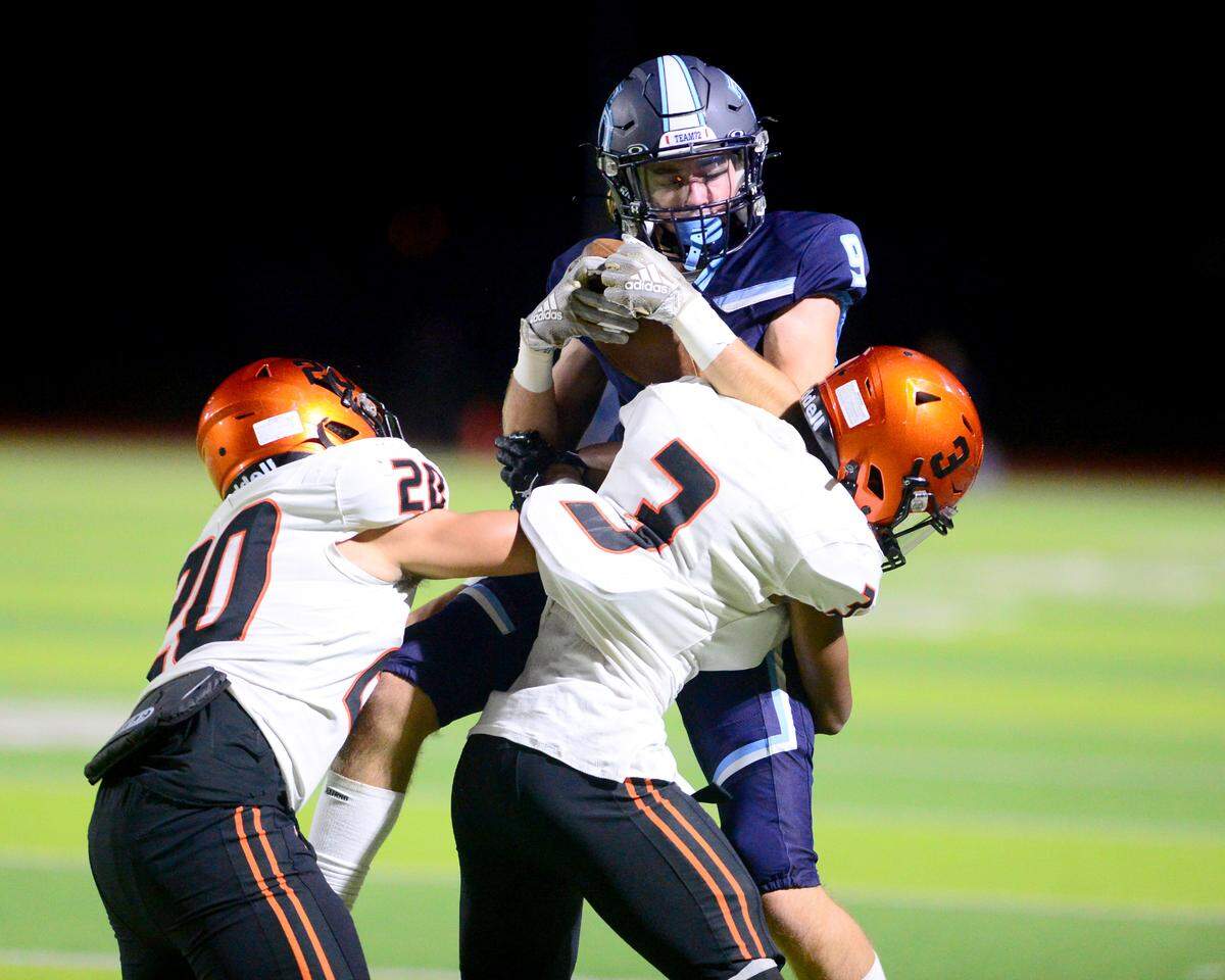Downey receiver Daley Holmes (9) gets hit after making a catch during a game between Downey High School and Merced High School at Downey High School in Modesto California on September 1, 2023.